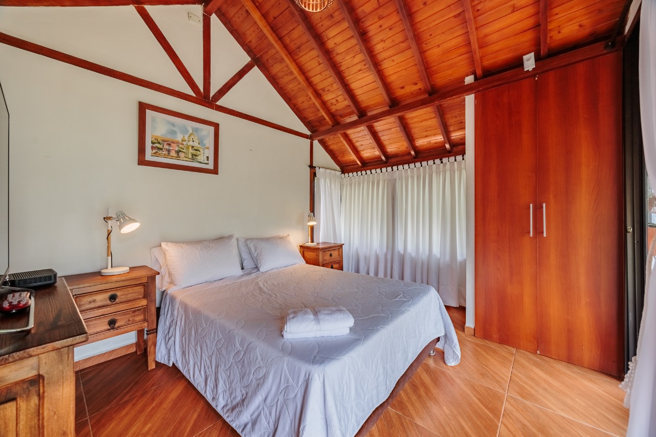 Habitación con techo en madera y cama doble