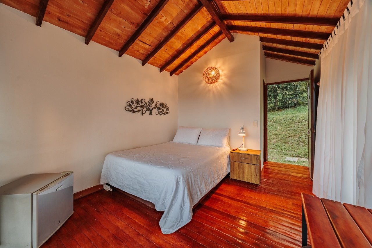 Habitación de madera con puerta abierta al jardín